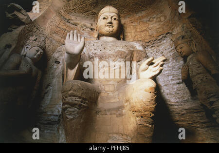 China, Shanxi, Yungang Caves, Cave 3, Buddha statue carved into the rock, low angle view. Stock Photo