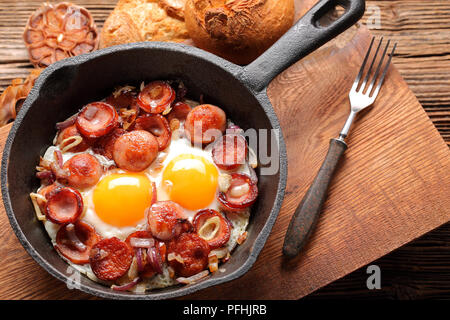 Cooked egg and sausages on frying pan Stock Photo