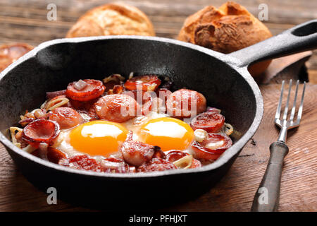 Cooked egg and sausages on frying pan Stock Photo