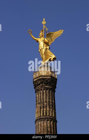 Germany, Berlin, Tiergarten, Siegessaeule, gold statue of winged woman personifying Victory, on top of column Stock Photo