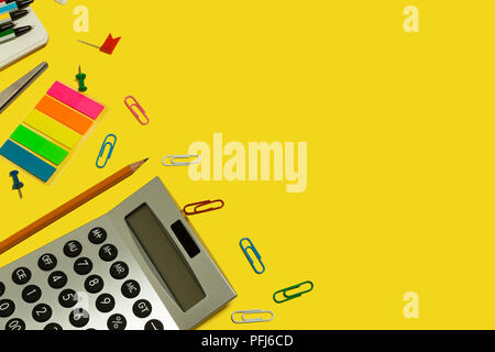 multiple school and office suplies and gadgets lying diagonally on a yellow background. free copyspace Stock Photo