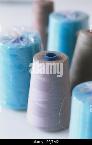 Five blue sewing threads on a white coils on a white background. Sewing ...