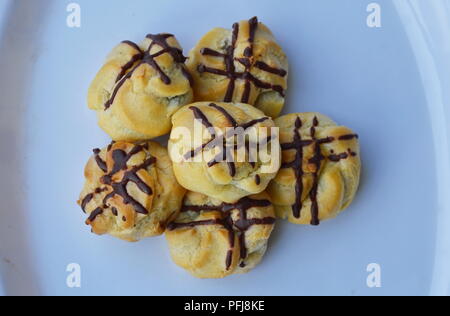 eclair filling chocolate cream on white plate Stock Photo