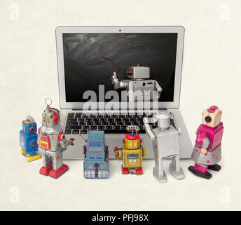 Machine learning concept with retro robots at a laptop computer isolated  E= mc Stock Photo
