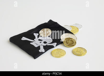 Pirate's purse with skull and crossbones on and fake gold and silver coins Stock Photo