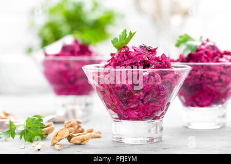 Beet salad. Salad of boiled beet. Beetroot salad with prune, walnuts and sour cream on white background Stock Photo