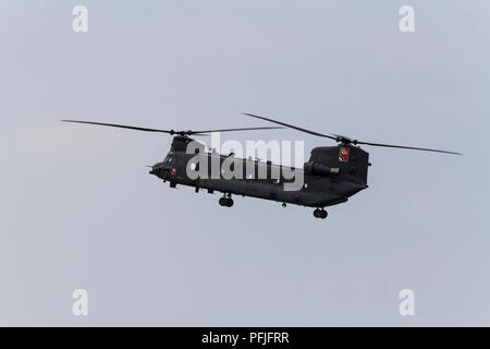 Chinook helicopter flying over shoreham UK coastal area. Vertical lift off and hovering heavy duty twin engine tandem rotors RAF transport aircraft. Stock Photo