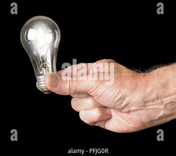 Mans hand holding an illuminated halogen lightbulb Stock Photo