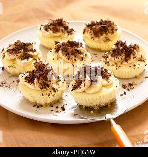 Mini banana chocolate cheesecakes on a plate, with cake server Stock Photo