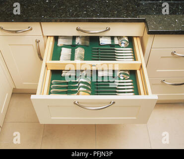 Set of silver cutlery neatly stored in kitchen cabinet drawer, close up, high angle view. Stock Photo