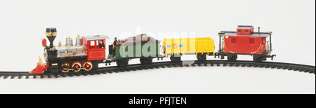 Toy locomotive and three carriages on a track, side view Stock Photo