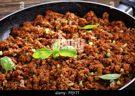 close-up of hot juicy ground beef stewed with tomato sauce, spices, basil, finely chopped vegetables and celery in frying pan, classic recipe, side vi Stock Photo