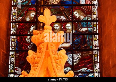 Great Britain, England, Hampshire, Romsey Abbey, carved stonework in front of stained glass window showing Jesus and apostles, close-up Stock Photo