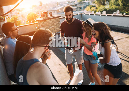 Group of happy friends having party on rooftop Stock Photo