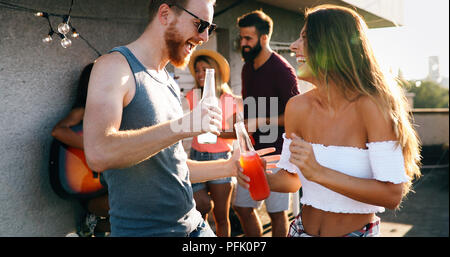 Friends having fun at rooftop party Stock Photo