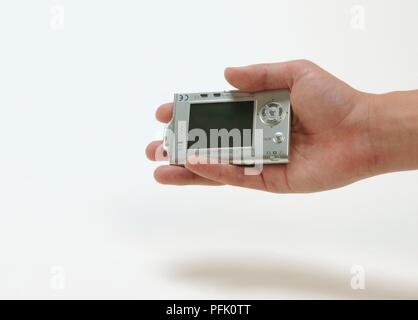 Man holding small digital camera in palm of hand Stock Photo