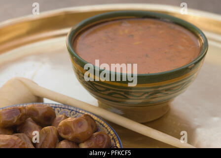 Bowl of Harira soup, made with chickpeas and lentils, served with dried dates, a traditional Moroccan dish eaten during Ramadan, close-up Stock Photo