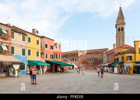 Sunset in the colourful fishing village on Burano Island, Venice, Veneto, Italy. Via Baldassare Galuppi, the main street, with shops, tourists and res Stock Photo