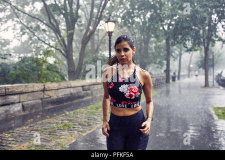 Hispanic Woman Running in the Rain Stock Photo