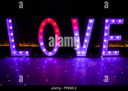 Illuminated Love sign in large letters at a wedding reception ready for the First Dance Stock Photo