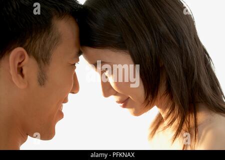 Headshot of man and woman standing face to face, side view Stock Photo