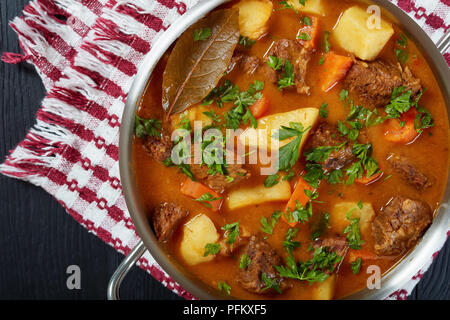 delicious braised beef with potato and carrots or estofado de carne in a casserole, view from above, close-up Stock Photo
