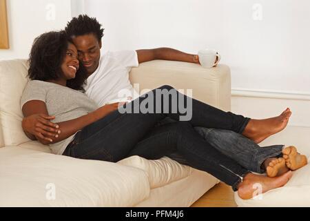Affectionate young couple relaxing on sofa Stock Photo