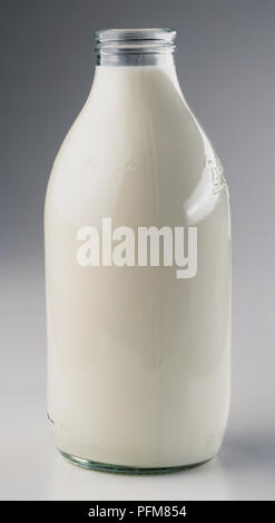 Open milk bottle, clear glass, filled to top Stock Photo