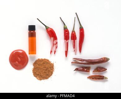 Capsicum frutescens (Cayenne), fresh and dried red cayenne chilli peppers, powdered chillies, ointment, and phial of infused oil Stock Photo