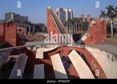 India, New Delhi, Jantar Mantar, obsolete observatory, large plaster astronomical instruments, Samrat Yantra, a gigantic sundial forming right-angled triangle, two brick quadrants measuring shadow, high-rise buildings in background. Stock Photo