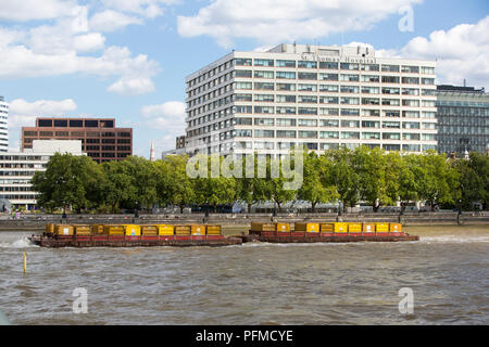 St Thomas's Hospital on the Thames embankment with a barge going down the Thames, London, UK. Stock Photo