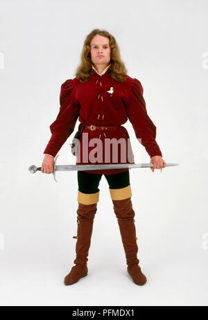 Man wearing medieval costume holding sword Stock Photo
