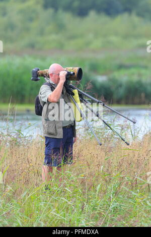A photographer searches for wildlife to photograph at RSPB St Aidan's, just one of many activities to do on the nature park near Leeds, Wes tYorkshire Stock Photo