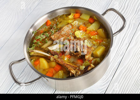 kjotsupa -  Icelandic Lamb winter hot Soup in a stainless steel casserole pan on wooden table, authentic recipe, horizontal view from above, close-up Stock Photo