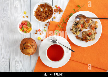 delicious freshly baked Homemade Banana Nut raisin Muffin on table and one muffin was broken into pieces on plate and served with cup of tea, view fro Stock Photo