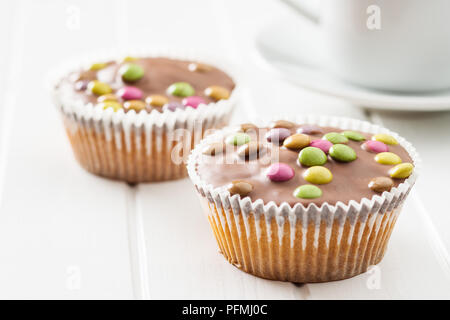 Sweet cupcakes with candies on white table. Stock Photo