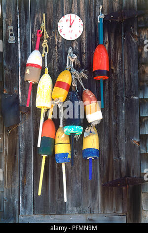 USA, New England, Maine, lobster trap buoys hanging on wall of shed Stock Photo
