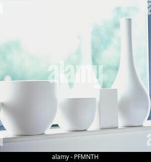 White ceramic pots and vases on window sill. Stock Photo