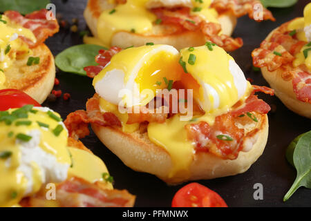 Eggs Benedict - toasted English muffins, fried crispy bacon, poached eggs and classic buttery hollandaise sauce served for breakfast, view from above, Stock Photo