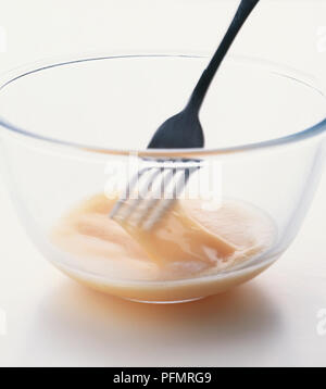 Vertical Shot of an Egg Wash in a Plate with Black Pastry Brush