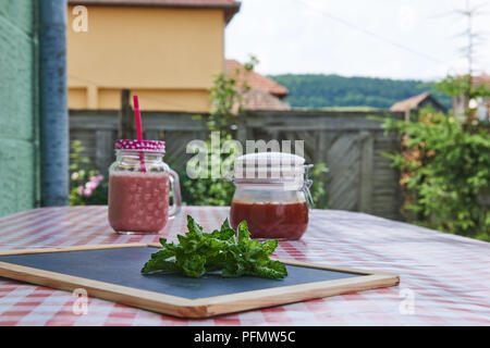 Fresh lemonade mint sugar cubes on red checkered tablecloth Stock Photo