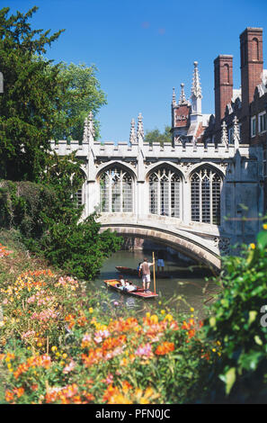 Great Britain, England, Cambridge, River Cam, people punting under Bridge of Sighs, profusion of colourful flowers on riverbank in front. Stock Photo