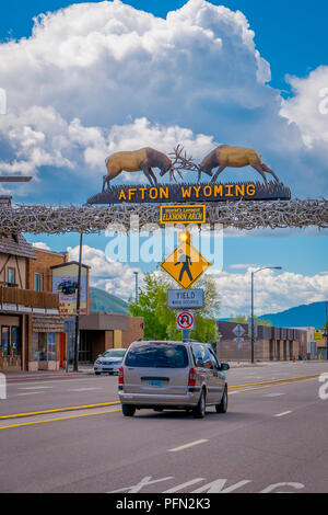Afton, Wyoming, United States - June 07, 2018: The world's larges elkhorn arch at the entrance of the town, with cars on the road and vehicles parked Stock Photo