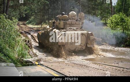Soldiers assigned to 2nd Battalion, 8th Cavalry Regiment, 1st Armored Brigade Combat Team, 1st Cavalry Division, conduct a river crossing during Saber Strike 18 at Drawsko Pomorskie Training Area, Poland, June 11, 2018. These Fort Hood, Texas, Soldiers are training in Poland as part of a regular rotation of US Forces in this region to strengthen NATO alliances. The Ironhorse brigade is currently deployed throughout Europe in support of Atlantic Resolve. (U.S. Army National Guard photo by Staff Sgt. Ron Lee, 382nd Public Affairs Detachment, 1ABCT, 1CD) Stock Photo