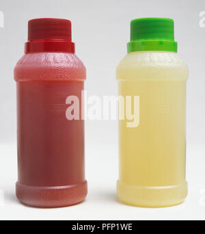 Two plastic bottles, one red with a red cap, and one yellow with a green cap Stock Photo