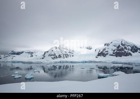 icecaps in the Antarctica with iceberg in the ocean swimming around and melting in the sea Stock Photo