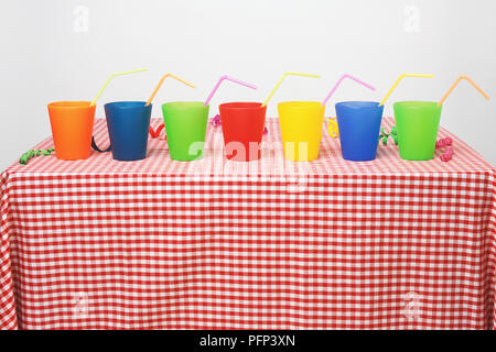 Seven plastic cups with drinking straws Stock Photo