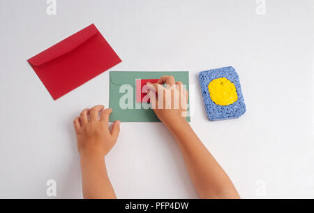 Girl printing seal on green envelope Stock Photo