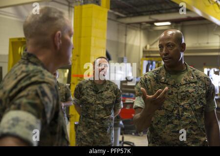 U.S. Marine Corps Lt. Col. Erik J. Smith, right, commanding officer of 2nd Maintenance Battalion, Combat Logistics Regiment 25, 2nd Marine Logistics Group, speaks to Lt. Gen. Mark A. Brilakis, left, Commander, U.S. Marine Corps Forces Command, during a command visit on Camp Lejeune, N.C., May 21, 2018. Brilakis visited 2nd Marine Logistics Group to better understand the unit’s operational capabilities. Stock Photo