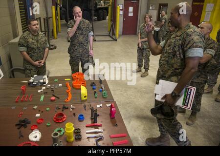 U.S. Marine Corps Lt. Col. Erik J. Smith, right, commanding officer of 2nd Maintenance Battalion, Combat Logistics Regiment 25, 2nd Marine Logistics Group, briefs Lt. Gen. Mark A. Brilakis, center, Commander, U.S. Marine Corps Forces Command, on the unit’s 3D printing capabilities during a command visit on Camp Lejeune, N.C., May 21, 2018. Brilakis visited 2nd Marine Logistics Group to better understand the unit’s operational capabilities. Stock Photo